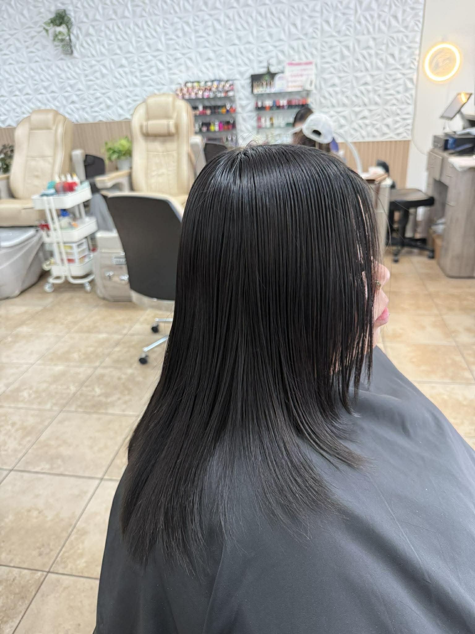 Straight dark hair with a soft salon backdrop